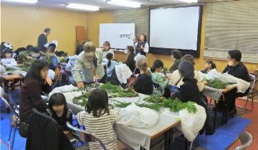 先生から素材の名前や特徴、グルーガンの注意を聞いています。