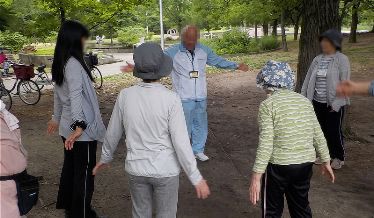 公園で講師と参加者が一緒に運動を行ううんどう教室