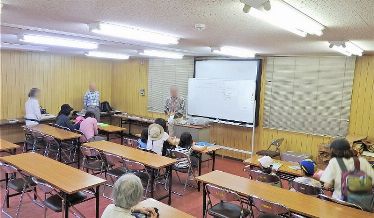 昆虫観察会で先生の話を聞く参加者たち